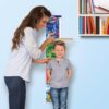 immagine del puzzle montato appeso al muro e la mamma misura l'altezza al bambino