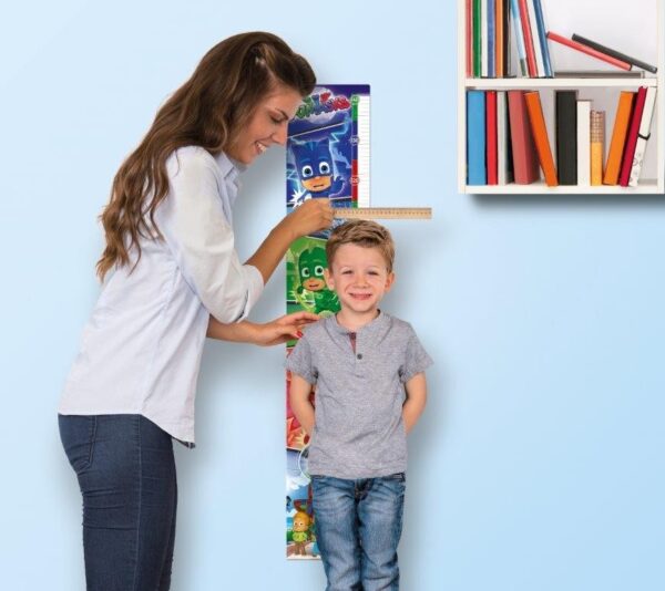 immagine del puzzle montato appeso al muro e la mamma misura l'altezza al bambino